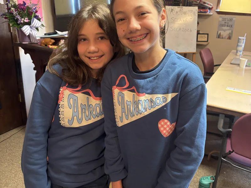 Two students smiling together indoors
