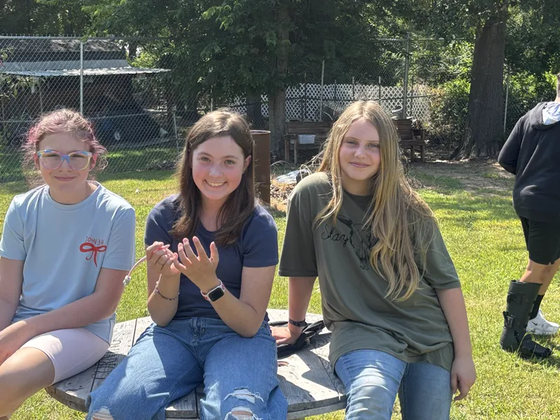 Three students sitting together on the grass