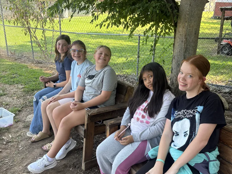 Students on a bench outside the school