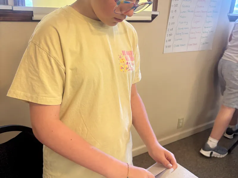 A student writing at the whiteboard
