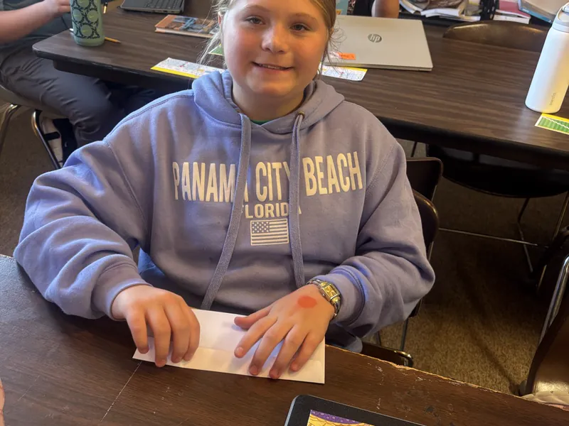 A student working through a worksheet at a table