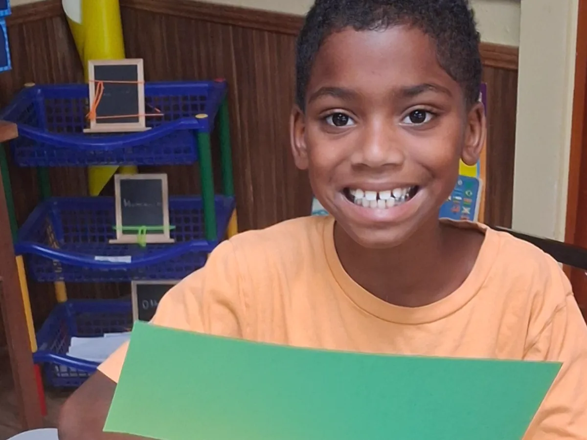 A student cutting shapes from colored paper in class